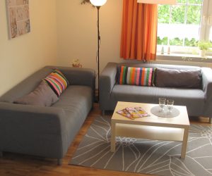 Wohnzimmer mit Couchgarnitur in der Ferienwohnung Muschel in Carolinensiel