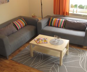 Wohnzimmer mit Couchgarnitur in der Ferienwohnung Muschel in Carolinensiel